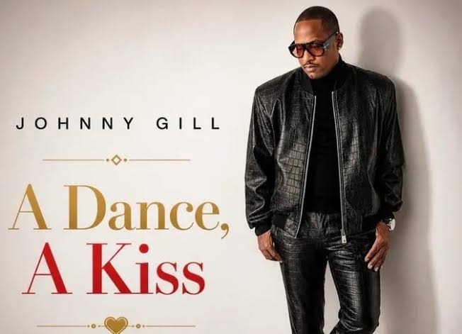 Album cover: Johnny Gill's 'A Dance, A Kiss' with Gill in a black leather outfit against a light background.