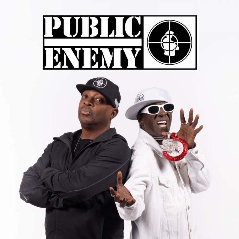 Public Enemy logo above two hip-hop artists posing, one in black with cap and the other in white jacket with a large clock necklace.